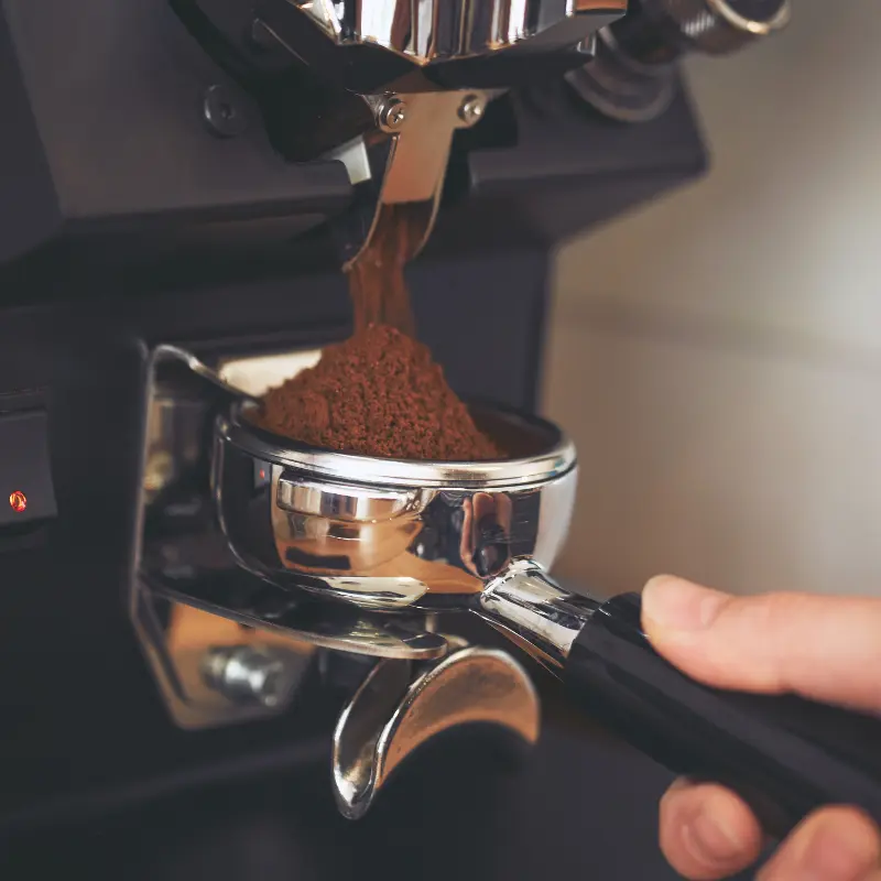 Beans being ground into a portafilter
